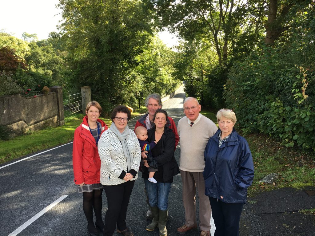 (L - R) Mrs Rhiannydd James, Headteacher of Ysgol Drewen; Elin Jones AM; Jake and Emma Morris with their son Madoc; County Cllr Lyndon Lloyd and Beulah Community Councillor Margaret Evans standing in front of the narrow bridge in Cwm Cou.
