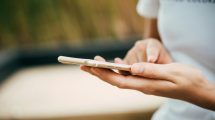 Person Standing While Using iPhone.