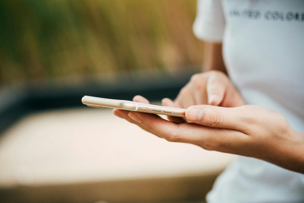 Person Standing While Using iPhone.